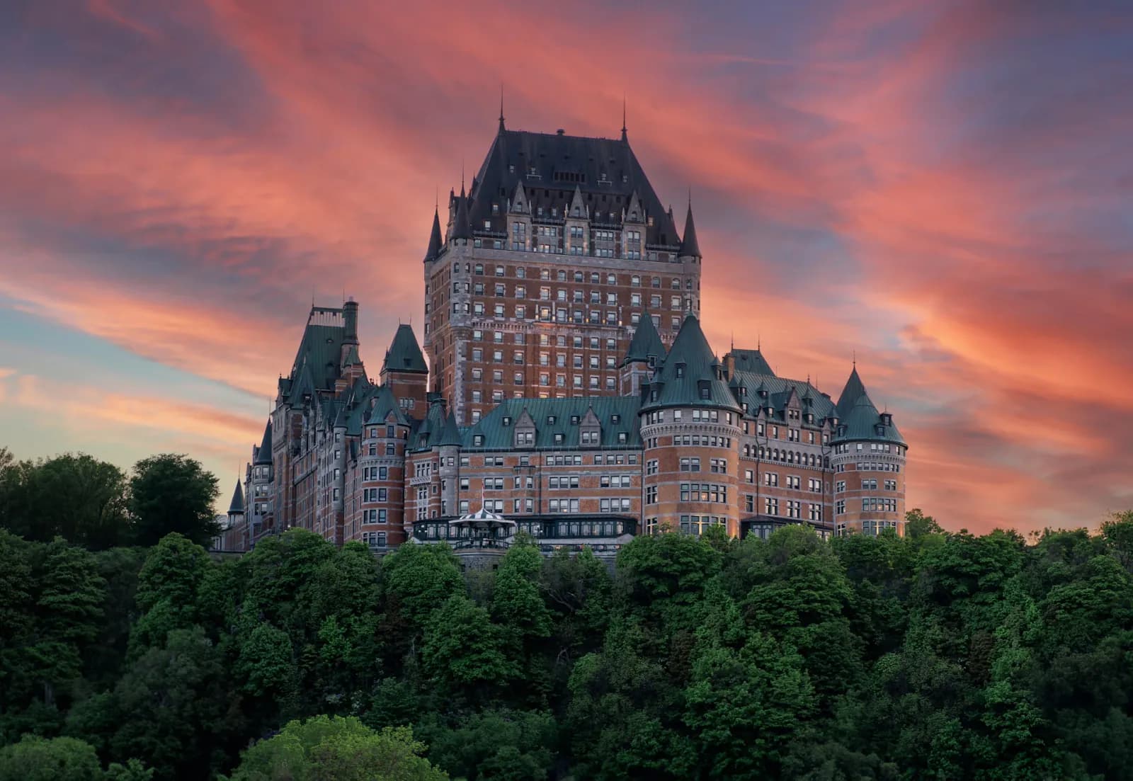Château Frontenac above Quebec City under a pink sunset sky