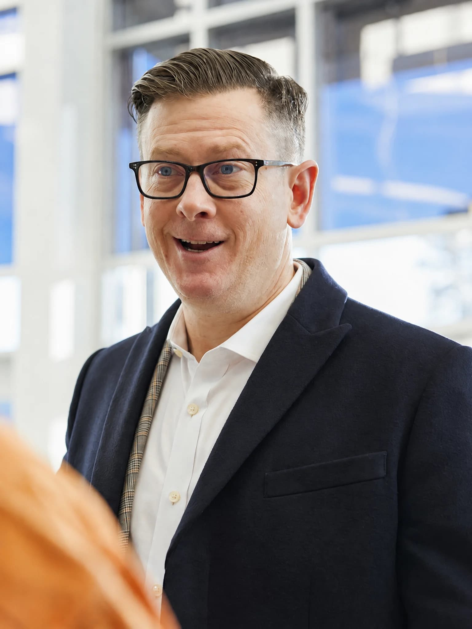 Man in glasses talking with another person